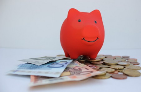 Rotes Sparkassenschwein auf Geldscheinen als Symbol für Sparkassenspenden.