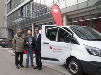 Michael Huber von der Sparkasse Karlsruhe übergibt den Kleinbus an die Vereinsvertreter der Sportjugend Vereinshilfe Karlsruhe.